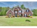 Beautiful two-story brick home with lush green lawn and mature landscaping, offering great curb appeal at 2417 Saint Feagin Pl, Powder Springs, GA 30127