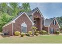 Charming red brick home with manicured front lawn and mature landscaping at 2417 Saint Feagin Pl, Powder Springs, GA 30127