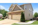 View of the side of a two-story home, showcasing the two-car garage and green lawn at 626 Discovery Ct, Acworth, GA 30102