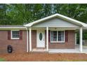 Close up of the brick exterior with a white door, shutters and a covered carport at 4781 Lincoln Ne Dr, Kennesaw, GA 30144