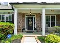 Inviting front porch with brick accents and decorative wreath on the front door at 1156 Whisper Cove Dr, Buford, GA 30518