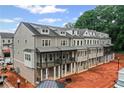 Modern townhome exteriors with gray siding and covered porches offer a stylish community under construction at 1975 Flying Scotsman Dr # 18, Kennesaw, GA 30144