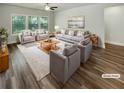 Bright, virtually staged living room with modern furniture, a large rug, and natural light streaming through the windows at 108 Hickory Run, Canton, GA 30115