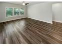 An empty living room with new wood laminate flooring, a ceiling fan, and natural lighting at 108 Hickory Run, Canton, GA 30115