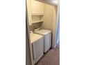 Convenient laundry area with modern washer, dryer, and built-in shelving for storage at 3990 N Quail Dr, Douglasville, GA 30135