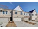 Inviting townhome featuring light brickwork, a two-car garage, and a neat front lawn under a blue sky at 4525 Twinberry Dr, Powder Springs, GA 30127
