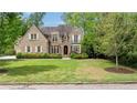 Attractive brick home with a manicured lawn and lush trees creating a private, inviting curb appeal at 1740 Doncaster Ne Dr, Atlanta, GA 30309