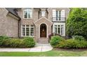 Inviting brick home with arched doorway and manicured shrubs at 1740 Doncaster Ne Dr, Atlanta, GA 30309