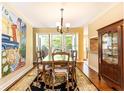 Bright dining room with large windows, hardwood floors, stylish decor, and traditional wooden furniture at 3910 Ashford Lake Ne Ct, Brookhaven, GA 30319