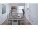 Bright dining room with classic decor, hardwood floors, a farmhouse dining table and access to the kitchen at 143 Lablanc Nw Way, Atlanta, GA 30327