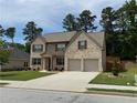 Beautiful two-story home featuring brick accents, a well-maintained lawn, and an attached two-car garage at 3531 Lilly Brook Dr, Loganville, GA 30052