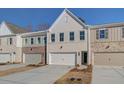 The exteriors of new townhomes with neutral colors, complemented by well-maintained driveways at 4517 Twinberry Dr, Powder Springs, GA 30127