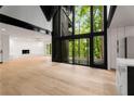 Modern living room featuring a stone fireplace, large windows with a view, and sleek design elements at 5020 Vallo Vista Ct, Atlanta, GA 30342