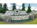 Stone entrance sign for Water Oak Estates with decorative landscaping and established trees at 553 Princeton Elm Place Way, Lawrenceville, GA 30045