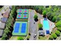 Aerial view of community tennis courts and pool, surrounded by lush greenery and neighborhood homes at 6468 Pierless Ave, Sugar Hill, GA 30518