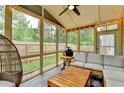 Relaxing screened-in porch featuring comfortable seating, a ceiling fan, string lights, and views of the backyard at 6468 Pierless Ave, Sugar Hill, GA 30518