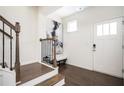 Welcoming foyer with hardwood floors, staircase, and a modern art piece enhancing the entryway's appeal at 875 Venture Sw Way, Atlanta, GA 30331