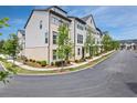 A wide view showcasing multiple townhomes along a tree-lined street with well-maintained landscaping at 2669 Caruso Way, Atlanta, GA 30339