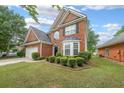 Beautiful two-story brick house with manicured lawn, mature landscaping, and attached two-car garage at 7979 Larksview Dr, Fairburn, GA 30213