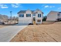Charming two-story home with white siding, black shutters, and a two-car garage against a clear blue sky at 19 Bridgemill Dr, Douglasville, GA 30134