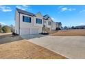 New two-story home with white siding, black shutters, a two-car garage, and ample parking space at 19 Bridgemill Dr, Douglasville, GA 30134