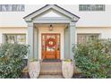 Charming entrance featuring a wooden door with a decorative wreath and potted plants at 228 Mount Vernon Dr, Decatur, GA 30030