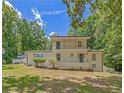 Charming two-story house with white exterior, upper balcony, surrounded by lush green trees, and blue skies at 315 Renae, Marietta, GA 30060