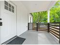 Close-up of a welcoming covered front porch with black railing, white trim, and a clean, modern aesthetic at 4103 Brenda Dr, Decatur, GA 30035