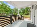 Spacious covered front porch with a view of lush greenery, featuring sleek black railings and a welcoming entrance at 4103 Brenda Dr, Decatur, GA 30035