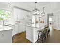 Bright kitchen features white cabinetry, modern stainless steel appliances, large island and hardwood flooring at 4314 Woodhaven Se Way, Smyrna, GA 30082