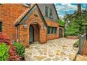 Inviting brick front porch with stone walkway features an arched entryway and lush landscaping at 50 Rumson Ne Way, Atlanta, GA 30305