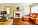 Cozy living room featuring hardwood floors, fireplace, bright windows, and comfortable seating at 50 Rumson Ne Way, Atlanta, GA 30305