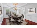 Formal dining room with elegant chandelier, detailed trim work, and gleaming hardwood floors at 2922 Heart Pine Way, Buford, GA 30519