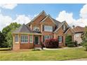 Beautiful brick home featuring a well-manicured lawn, dark shutters, and lovely landscaping at 2922 Heart Pine Way, Buford, GA 30519
