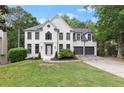 Beautifully landscaped front yard and well-maintained lawn with an inviting white brick home and gray garage doors at 4294 Silver Peak Pkwy, Suwanee, GA 30024