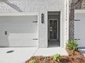 Close up of the front door and garage featuring painted brick and a convenient two car garage at 4651 Larkfield Way, Powder Springs, GA 30127