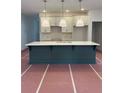 A kitchen island with a white countertop and blue base is featured beneath three pendant lights at 4651 Larkfield Way, Powder Springs, GA 30127