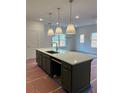 A kitchen island with white countertops, a sink, and pendant lights above it is shown at 4651 Larkfield Way, Powder Springs, GA 30127