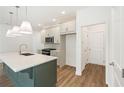 Well-lit kitchen featuring a spacious island with a sink, stainless steel appliances, and sleek countertops at 4651 Larkfield Way, Powder Springs, GA 30127