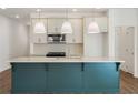 Modern kitchen boasts a large island with seating, stainless steel appliances, and stylish pendant lighting at 4651 Larkfield Way, Powder Springs, GA 30127