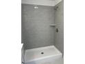 A modern shower with gray brick-patterned tile and a built-in shelf is showcased at 4651 Larkfield Way, Powder Springs, GA 30127