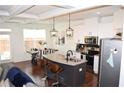Open-concept kitchen with granite island, stainless appliances, and modern pendant lighting at 7624 Squire Ct, Fairburn, GA 30213