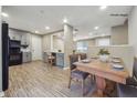 Open-concept dining room with wood floors, connecting the kitchen and living areas at 8227 Englewood Trl, Riverdale, GA 30274