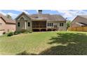 Back exterior view of home featuring a screened porch and a well maintained large lawn area at 2084 Democracy Dr, Buford, GA 30519