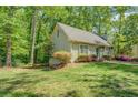 Side view of cozy home surrounded by greenery and beautiful landscaping, providing a private and serene setting at 3957 Woodland Cir, Conyers, GA 30013