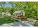 A well-maintained lawn and colorful flower beds add to the curb appeal of this one-story home surrounded by mature trees at 3957 Woodland Cir, Conyers, GA 30013