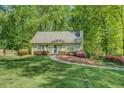 A well-manicured lawn and vibrant azaleas enhance the curb appeal of this home with light green paint and a blue front door at 3957 Woodland Cir, Conyers, GA 30013