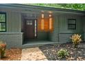 Close-up of a covered front porch with wood door, address number, and modern lighting at 4206 Lake Laurel Se Dr, Smyrna, GA 30082