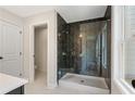 Modern bathroom featuring a glass-enclosed shower with dark herringbone tile and ample natural light at 4671 Larkfield Way, Powder Springs, GA 30127