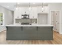 Stylish kitchen with a gray island, white cabinets, stainless steel appliances, and modern pendant lighting at 4671 Larkfield Way, Powder Springs, GA 30127